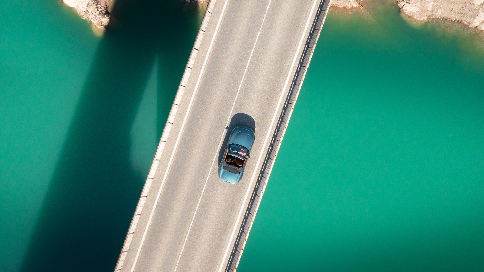 Aerial shot of a car driving over a bridge