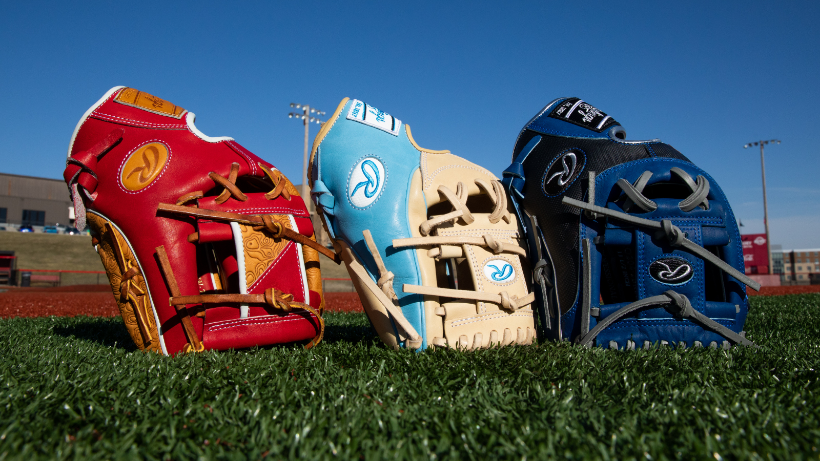 Three baseball gloves standing next to one another, opening facing the sky