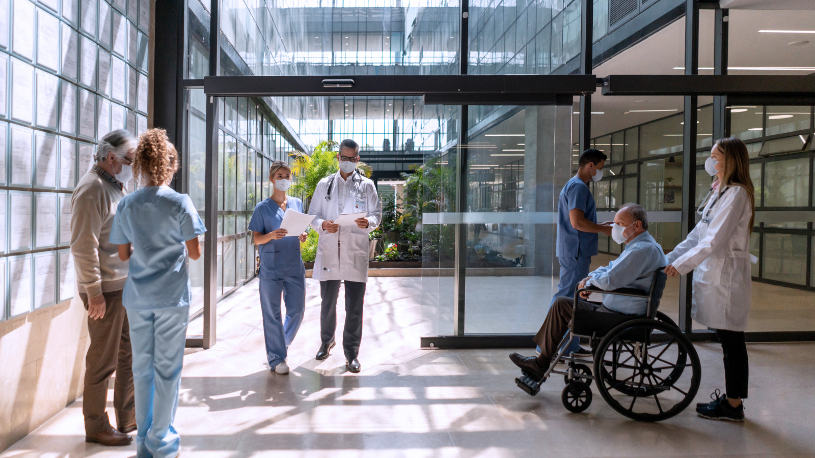 Group of healthcare workers and patients in a hospital lobby