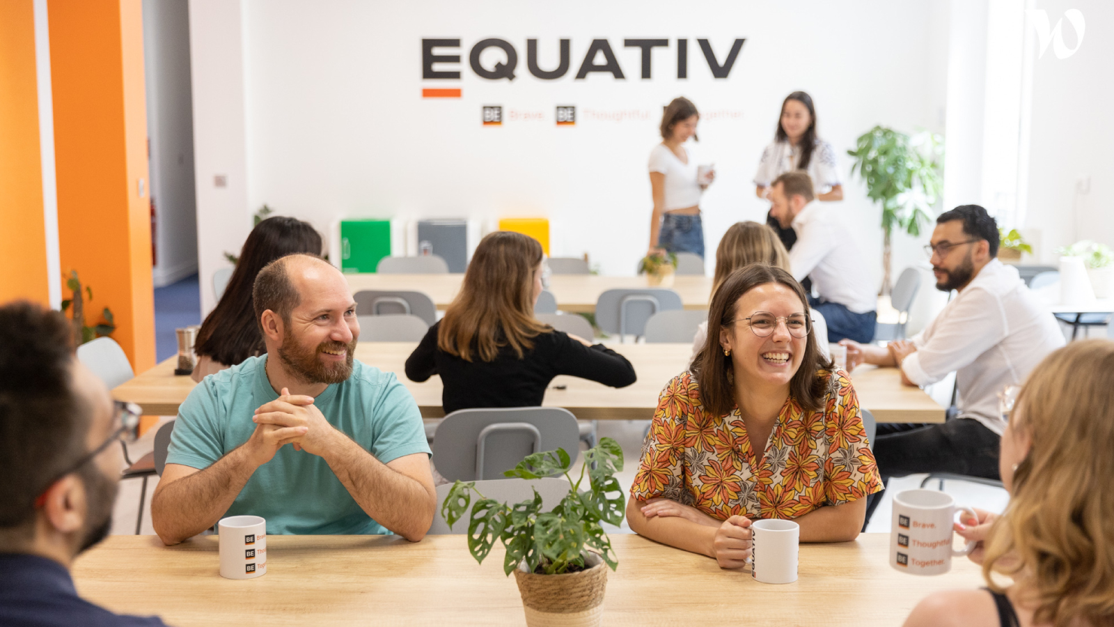 Equativ employees talking and smiling at tables