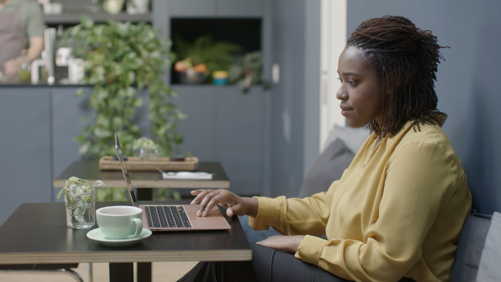 Image of a woman sitting at a desk working on a laptop