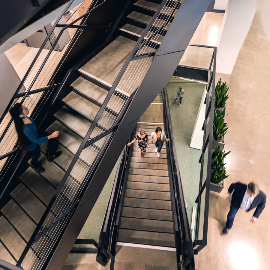 Office workers using an stairs to move between floors, reflecting the dynamic nature of a bustling workplace.