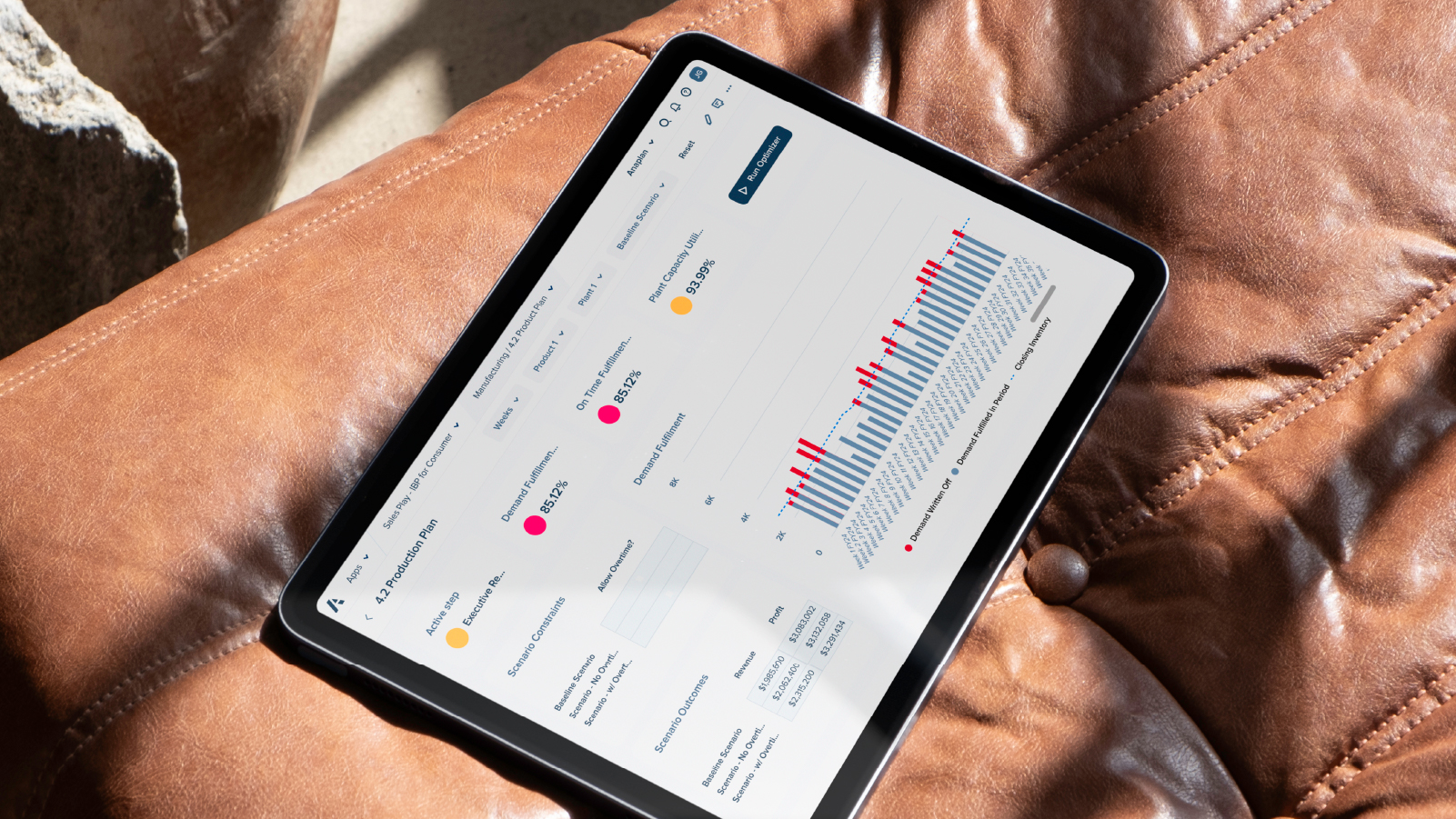 Tablet Production Planning dashboard image Image of a tablet placed on a leather couch showing a Production planning dashboard view