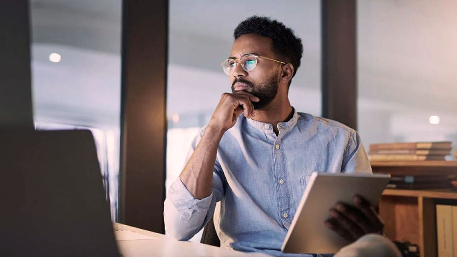 Anaplan eBook on finance leaders guide to business transformation in tech, media, and telecom. The text highlights strategies for finance leaders to drive digital transformation, with an image of a professional in a thoughtful pose holding a tablet.