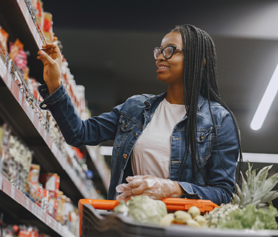 A woman selecting fresh produce in a grocery store aisle, focused on her shopping choices.