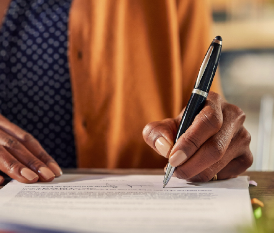 Signing a contract, using a pen to finalize an important document.