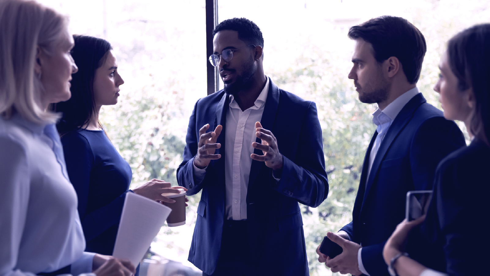 Group of colleagues speaking by a window