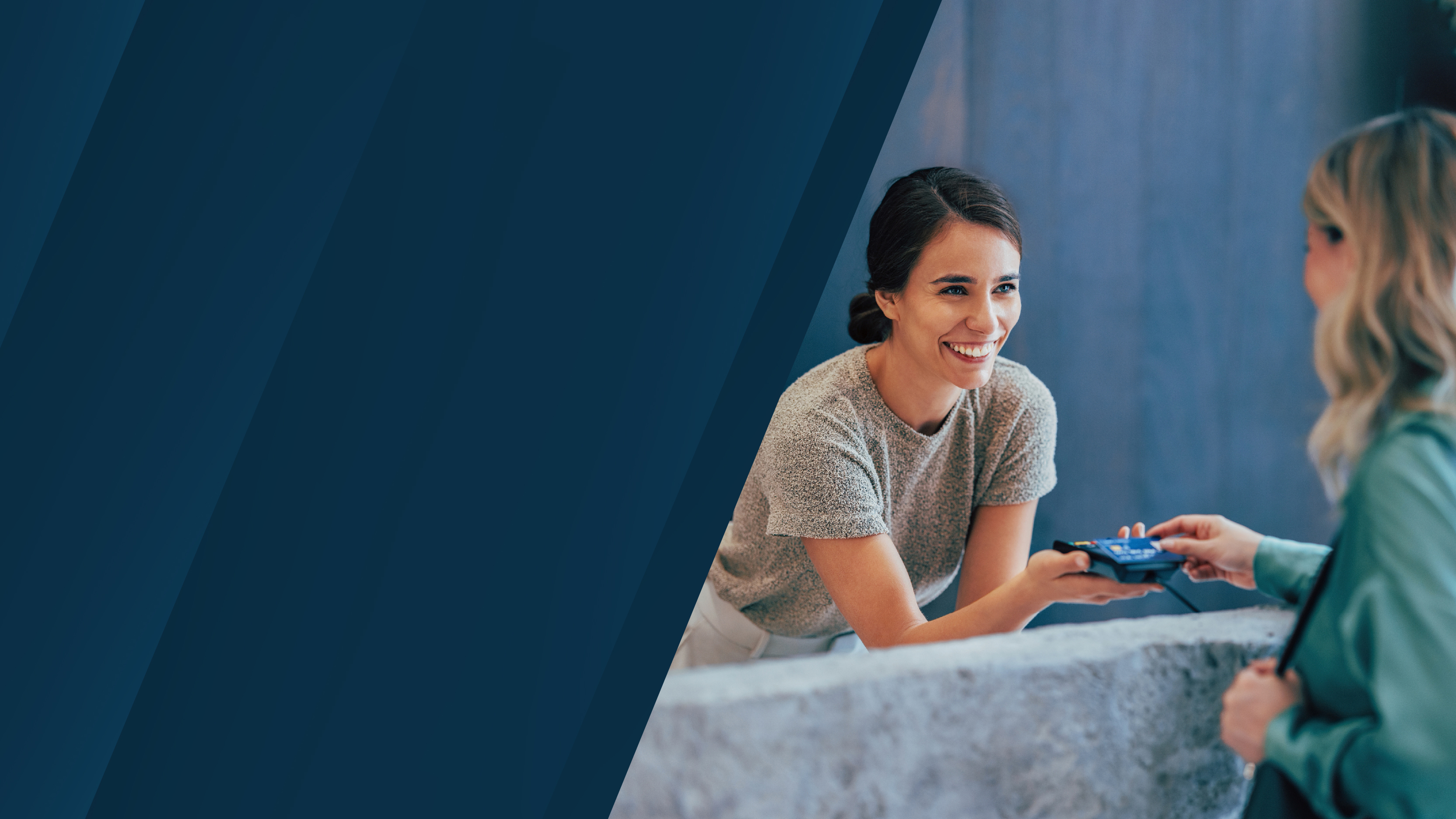 A retail interaction where a smiling woman at a counter hands a payment terminal to a customer. The image includes a dark blue design element on the left.