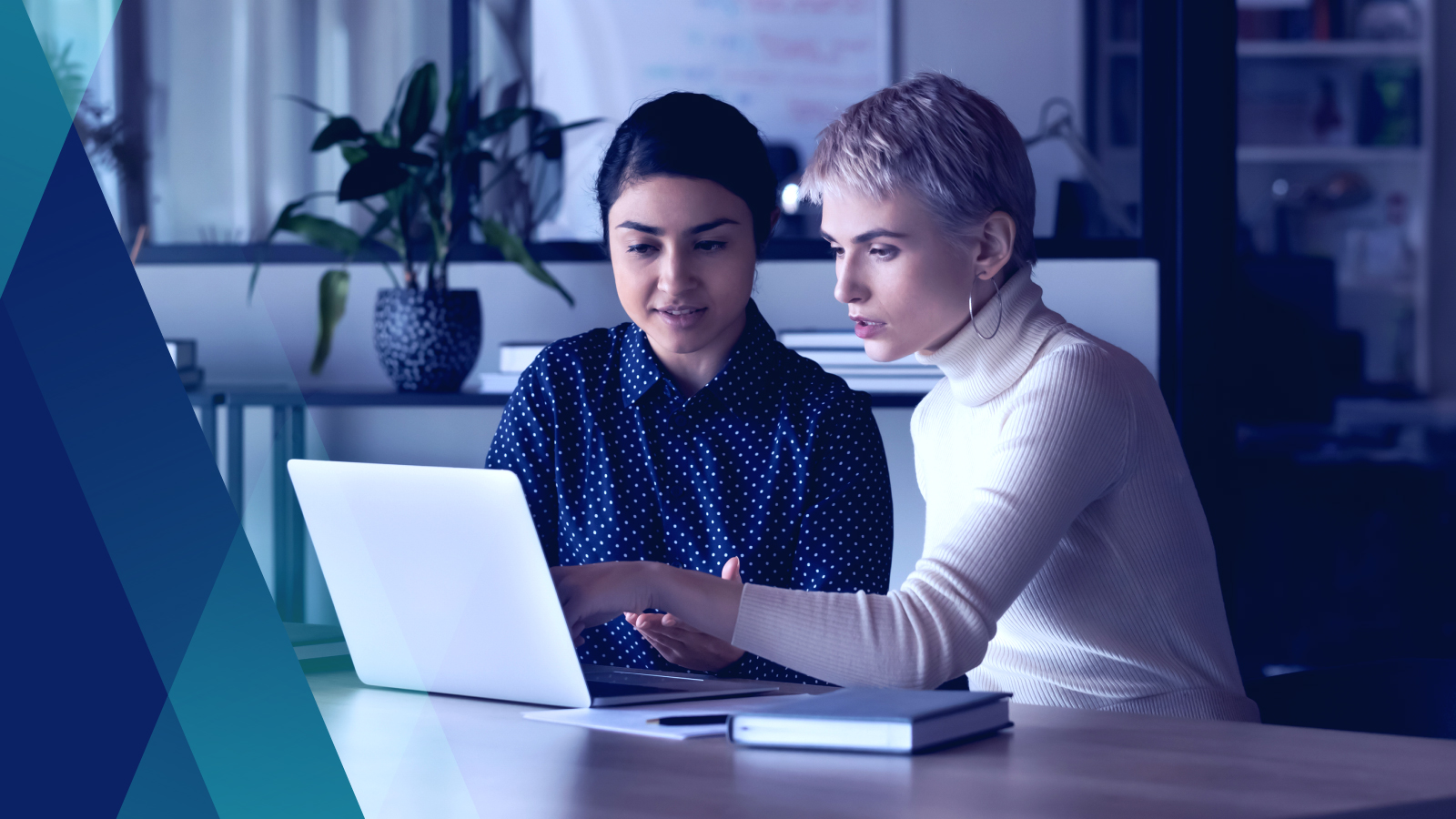 Two coworkers collaborating on a computer in an office